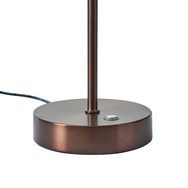 Runder Lampenfuß aus bronzefarbenem Metall mit einem Druckknopf und Stromkabel.