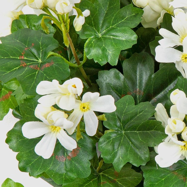Künstliche Geranie mit weißen Blüten und grünen Blättern.