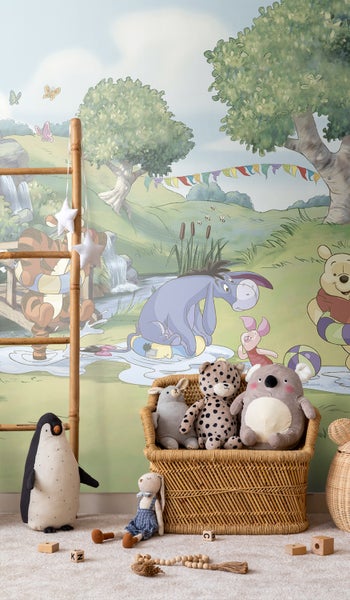 Kinderzimmer mit Winnie Puh Tapete und Stofftieren in einem Korb
