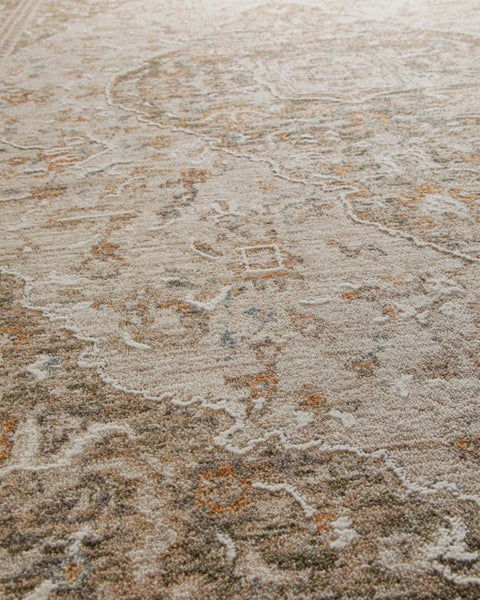 Detailansicht eines Teppichs mit orientalischem Muster im Vintage-Look in Beige, Grau und Orange.