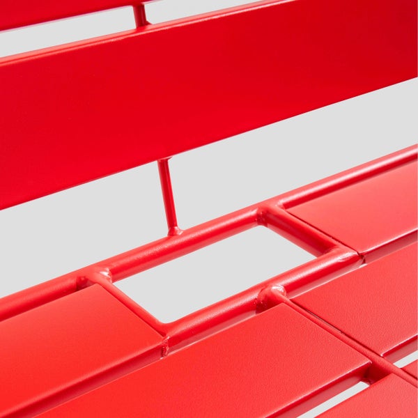 Nahaufnahme einer roten Gartenbank aus Metall mit flachen Latten und Rohrgestell.
