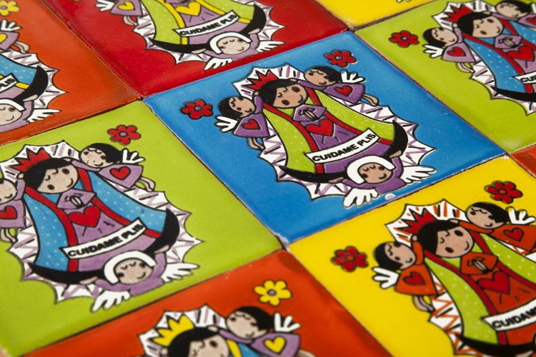 Fliesen mit einer kindlichen Zeichnung einer Figur und dem Text Cuídame Plis