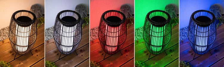 Solar-Außenleuchte in Rattan-Optik mit RGB-Farbwechsel auf einer Holzterrasse in verschiedenen Lichtfarben.