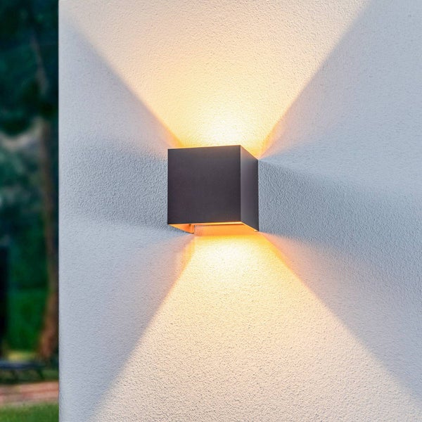 Quadratische LED-Außenwandleuchte in Anthrazit mit Up-and-Down-Lichteffekt an einer strukturierten Fassade.