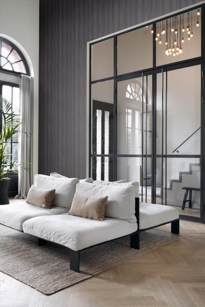 Modernes Wohnzimmer mit Sofa, Teppich und Glastüren