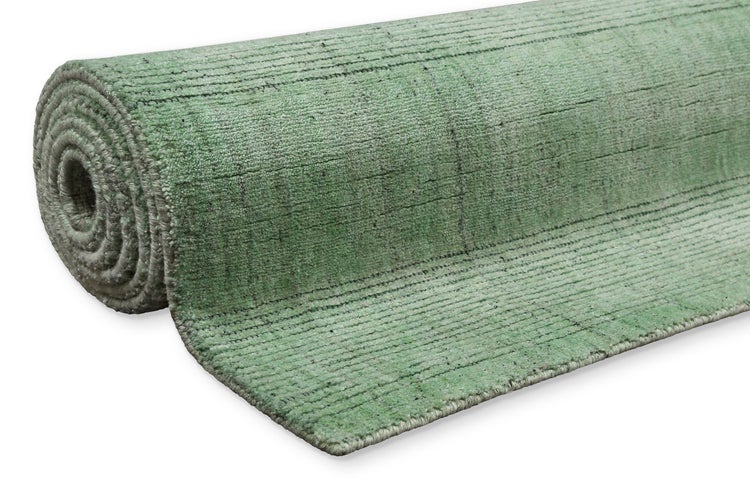 Gerollter grüner Teppich mit gerippter Struktur.