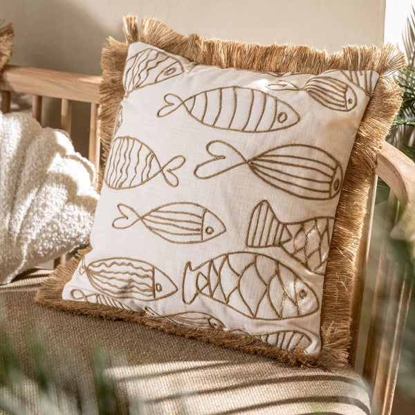 Dekokissen mit Fischmuster und Fransen auf Holzstuhl