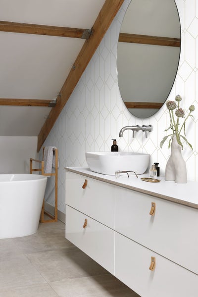 Badezimmer mit Waschbecken, Spiegel und geometrischer Tapete