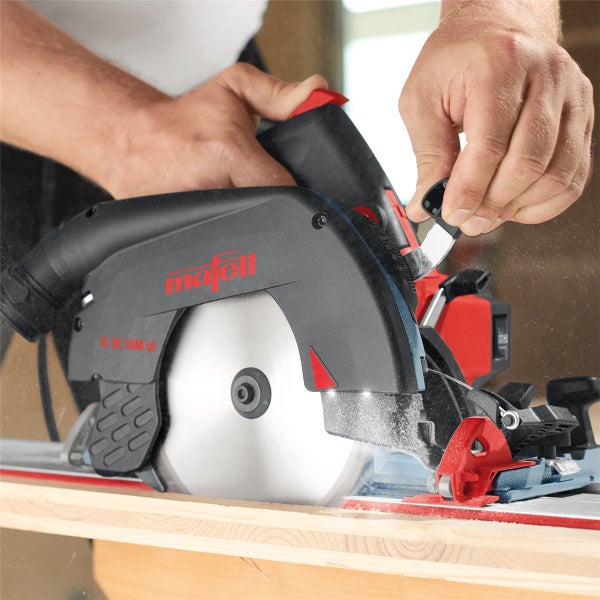 Handwerker bedient eine Mafell Handkreissäge K 55 18M bl beim Sägen von Holz auf einer Führungsschiene.