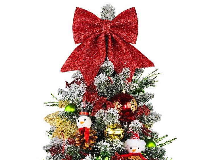 Künstlicher Weihnachtsbaum mit Schneebeflockung und festlicher Dekoration wie einer großen Schleife, Weihnachtskugeln und Schneemannfiguren