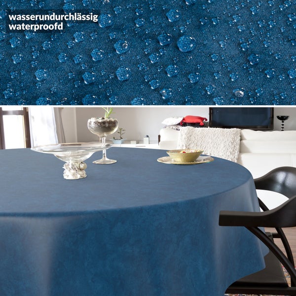 Wasserundurchlässige, runde Tischdecke in Blau auf einem Esstisch in einem hellen Wohnzimmer. Detailansicht zeigt abperlende Wassertropfen.