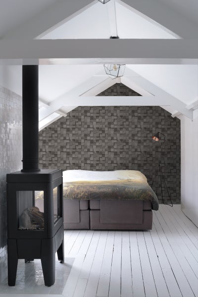 Schlafzimmer im Dachgeschoss mit Kaminofen, Boxspringbett und gemusterter Tapete