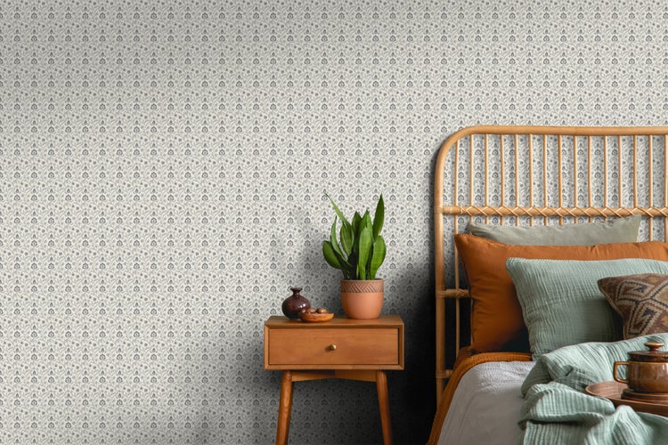 Gemütliches Schlafzimmer mit gemusterter Tapete, Rattanbett und Nachttisch