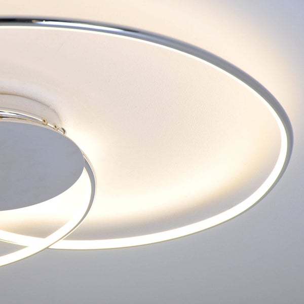 Detailansicht einer modernen LED-Deckenleuchte in Ringform mit Metallelementen im eingeschalteten Zustand.