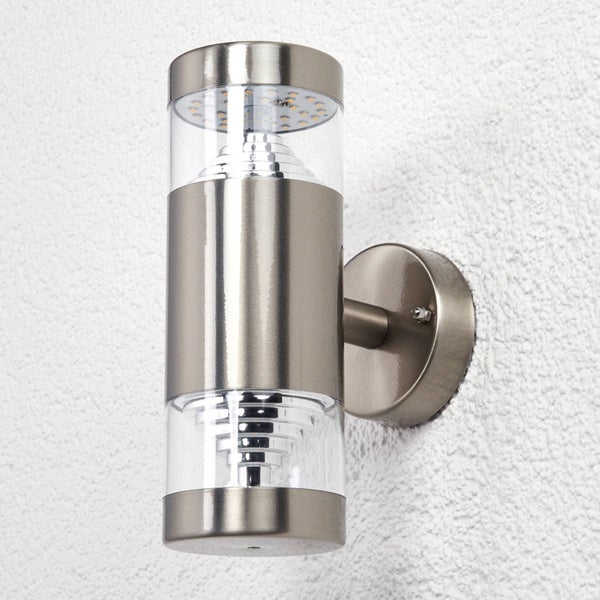 Zylindrische Außenwandleuchte aus Edelstahl mit klaren Kunststoffeinsätzen für Lichtaustritt nach oben und unten.