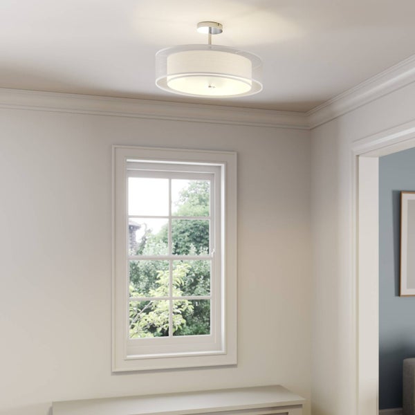 Moderne Deckenleuchte mit Stoffschirm und Glasring in einem hellen, minimalistischen Raum mit großem Fenster und Blick ins Grüne.