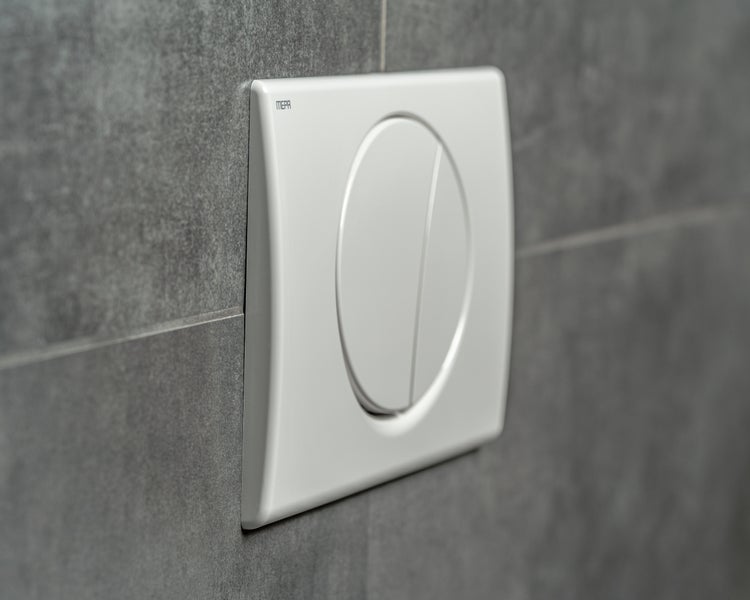 MEPA Betätigungsplatte für zwei Mengen Spülung, montiert an einer Fliesenwand.