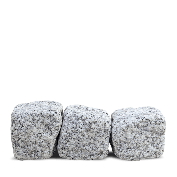 Drei Pflastersteine aus Granit mit bruchrauer Oberfläche in Reihe.