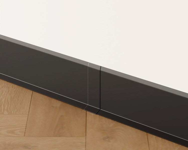 Sockelleiste aus Kunststoff zwischen Holzboden und weißer Wand