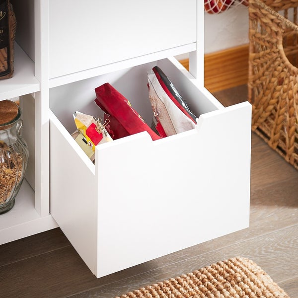 Detailansicht eines weißen Regalschranks mit offener Schublade, gefüllt mit Snacks