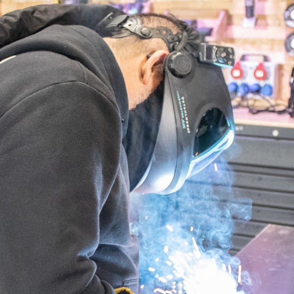 Schweißer mit Schweißhelm in Aktion.