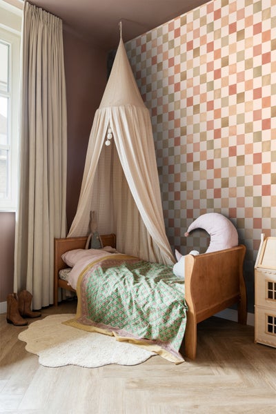 Kinderzimmer mit Himmelbett, gemusterter Tapete und dekorativen Elementen