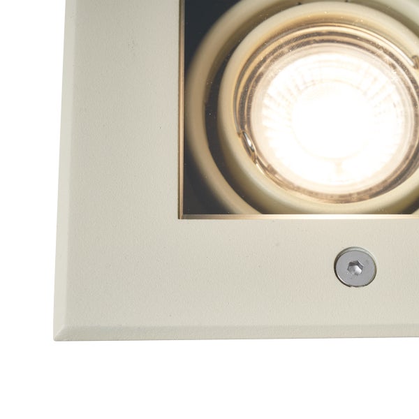 Quadratischer Bodeneinbaustrahler mit eingeschaltetem rundem Leuchtmittel und sichtbarer Schraube auf dem Rahmen.