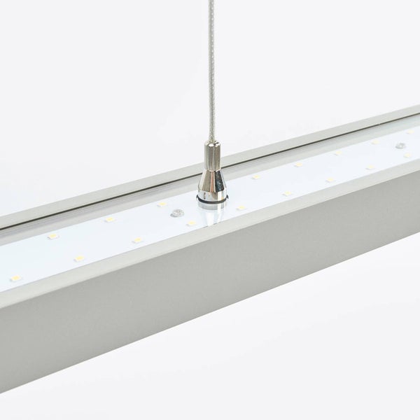 Nahaufnahme eines silbernen LED-Profils aus Aluminium mit integriertem LED-Streifen und einem Aufhängeseil aus Metall.