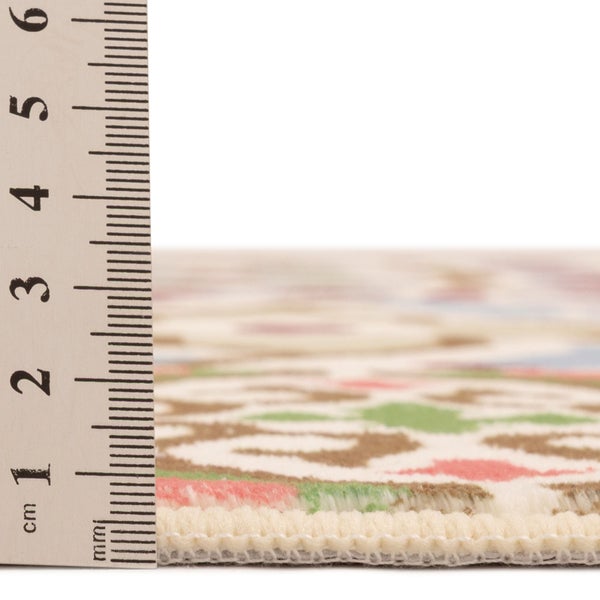 Lineal misst die Florhöhe eines gemusterten Teppichs.