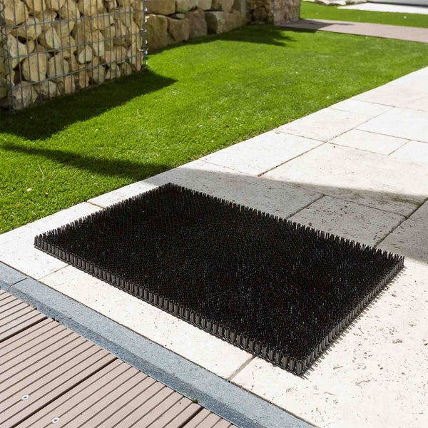 Eine schwarze Katzenabwehrmatte liegt auf einer Terrasse.