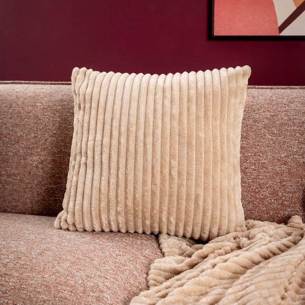 Quadratisches Cordkissen auf einem Sofa