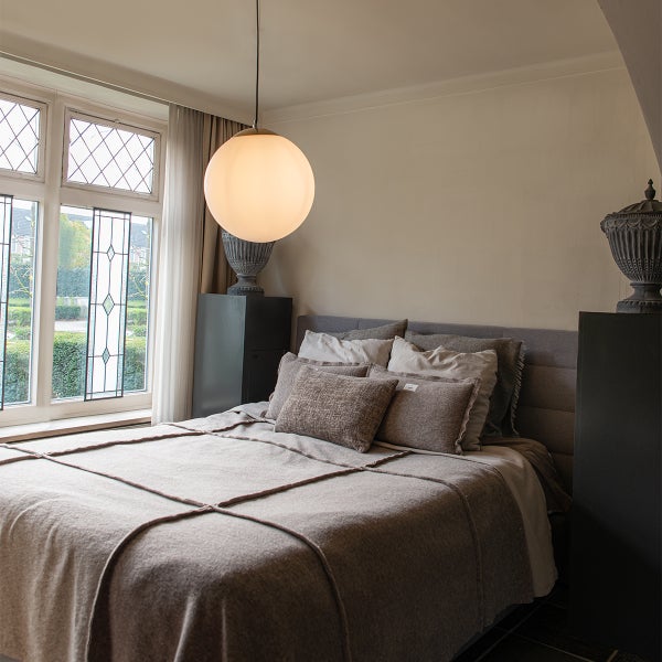 Schlafzimmer mit Bett, Nachttischen, Dekoration und Pendelleuchte