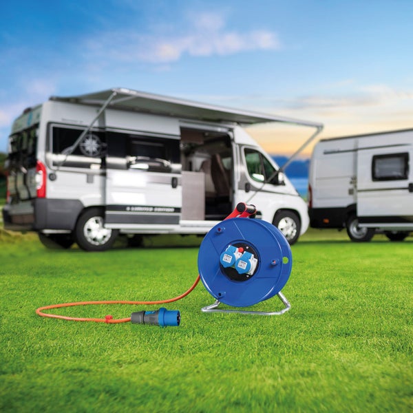 Blaue Kabeltrommel mit Stecker und zwei Wohnmobilen im Hintergrund.