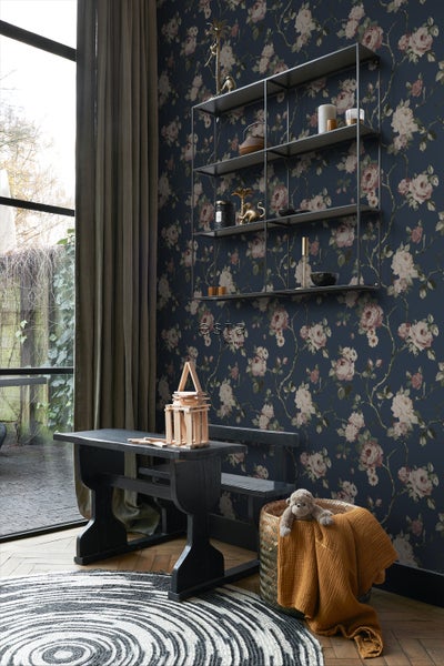 Wohnraum mit floraler Tapete, Regal, Tisch und dekorativen Elementen für ein gemütliches Ambiente
