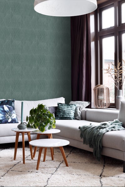 Wohnzimmer mit Sofa, Beistelltischen und geometrischer Tapete.