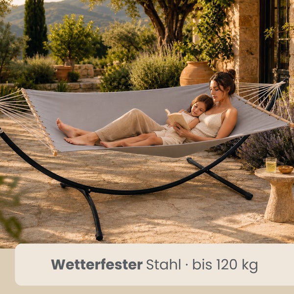Hängematte mit Gestell aus wetterfestem Stahl, Belastbarkeit bis zu 120 Kilogramm, genutzt von zwei Personen in einer hellen Gartenumgebung.