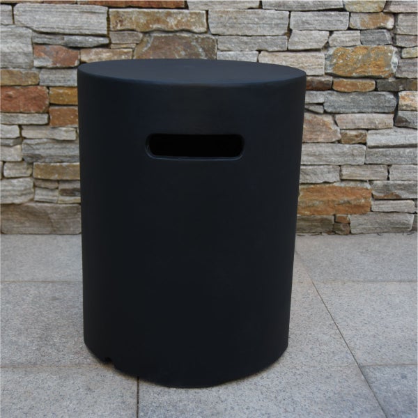 Zylindrischer Beistelltisch oder Hocker in Schwarz mit praktischer Grifföffnung vor einer Steinwand im Außenbereich.