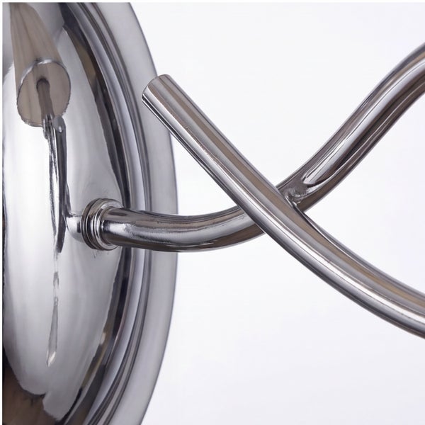 Nahaufnahme einer verchromten Metallleuchte mit geschwungenem Arm und runder Basis.