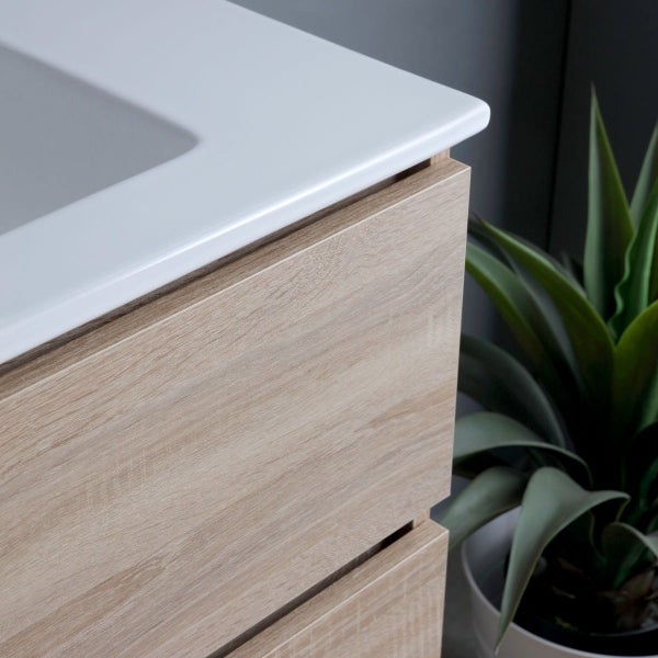 Detailaufnahme eines Waschtischunterschranks mit hellem Holzdekor und Keramikwaschbecken