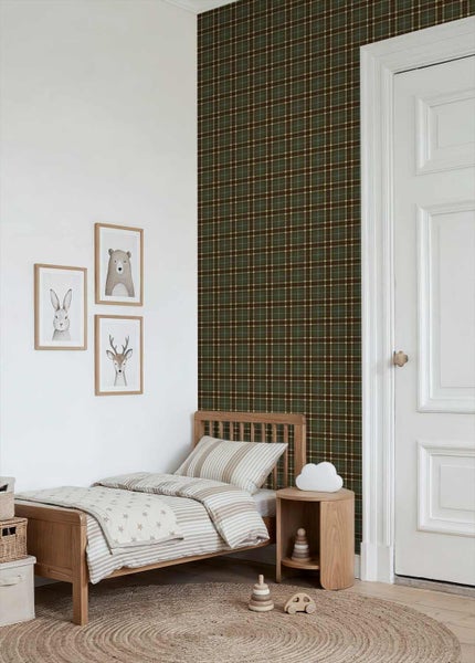 Kinderzimmer mit einer Akzentwand aus dunkler karierter Tapete, einem Holzbett mit gestreifter Bettwäsche und drei Tierbildern an der Wand.