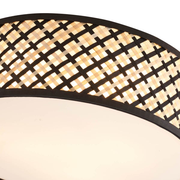 Detailaufnahme einer Deckenleuchte mit geflochtenem Lampenschirm.