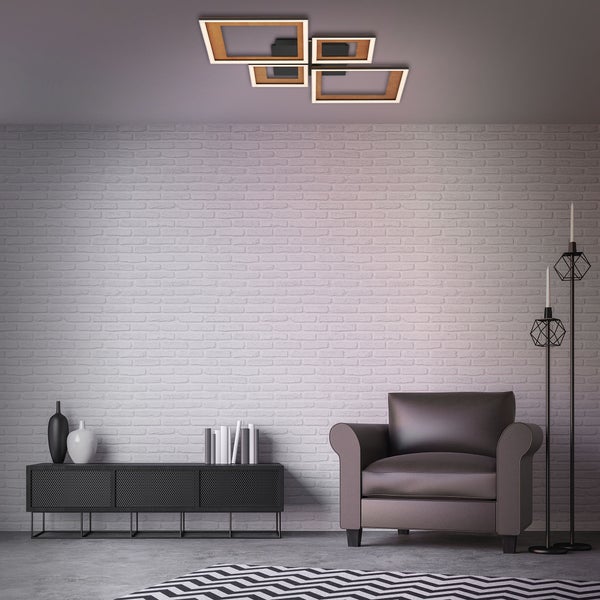 Moderne 4-flammige LED-Deckenleuchte in Holzoptik im Wohnzimmer mit Backsteinwand und Sessel.