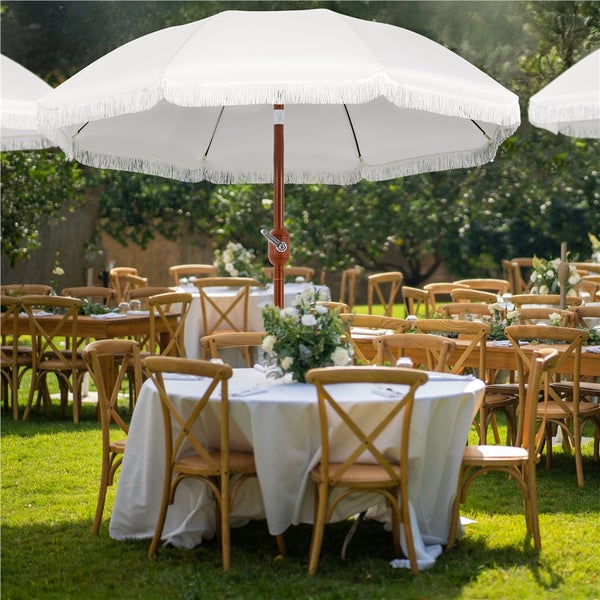 Szene mit Sonnenschirmen, Tischen und Stühlen im Freien für eine Veranstaltung