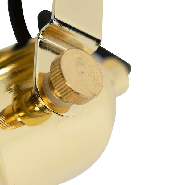Detailaufnahme einer goldenen Leuchte mit Einstellschraube