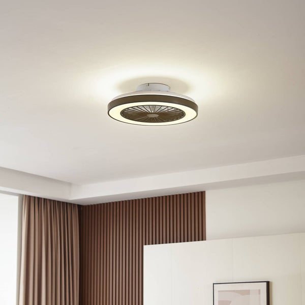 Moderner Deckenventilator mit integriertem LED-Lichtring, montiert an einer weißen Decke in einem hellen Raum mit Holzlamellenwand.