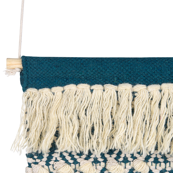 Wandbehang aus Textil mit blauem Webmuster, hellen Fransen und einem Holzstab zur Aufhängung.