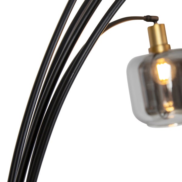 Detailaufnahme einer Stehlampe mit mehreren Armen und einem grauen Glasschirm.