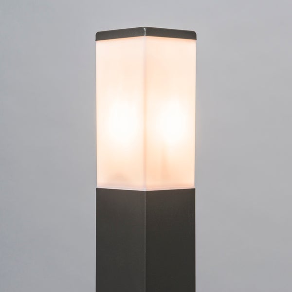 Moderne quadratische Außenstehleuchte mit dunkelgrauem Metallsockel und beleuchtetem mattem Diffusor.