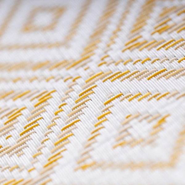 Nahaufnahme eines gewebten Teppichs mit geometrischem Muster