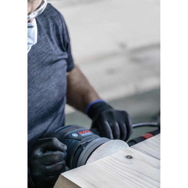 Ein Mann schleift Holz mit einem Exzenterschleifer von Bosch